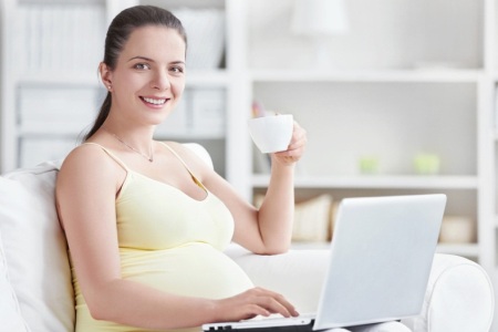 Беременная держит кружку: для профилактики запоров во время беременности нужно пить достаточно жидкости.